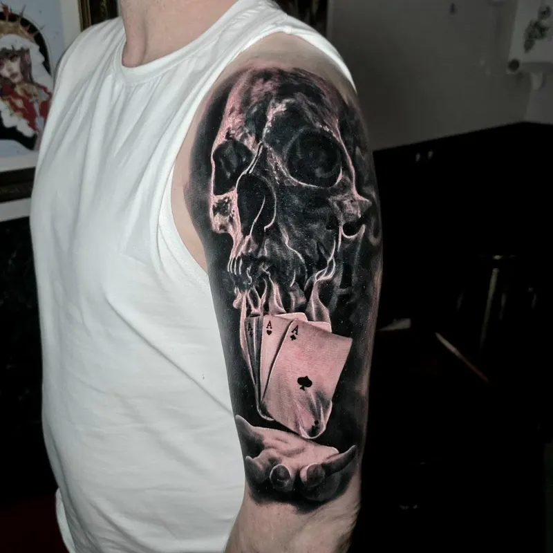 Black and grey realism skull and playing cards tattoo by Tomek Turlej, Studio XIII Gallery, Edinburgh
